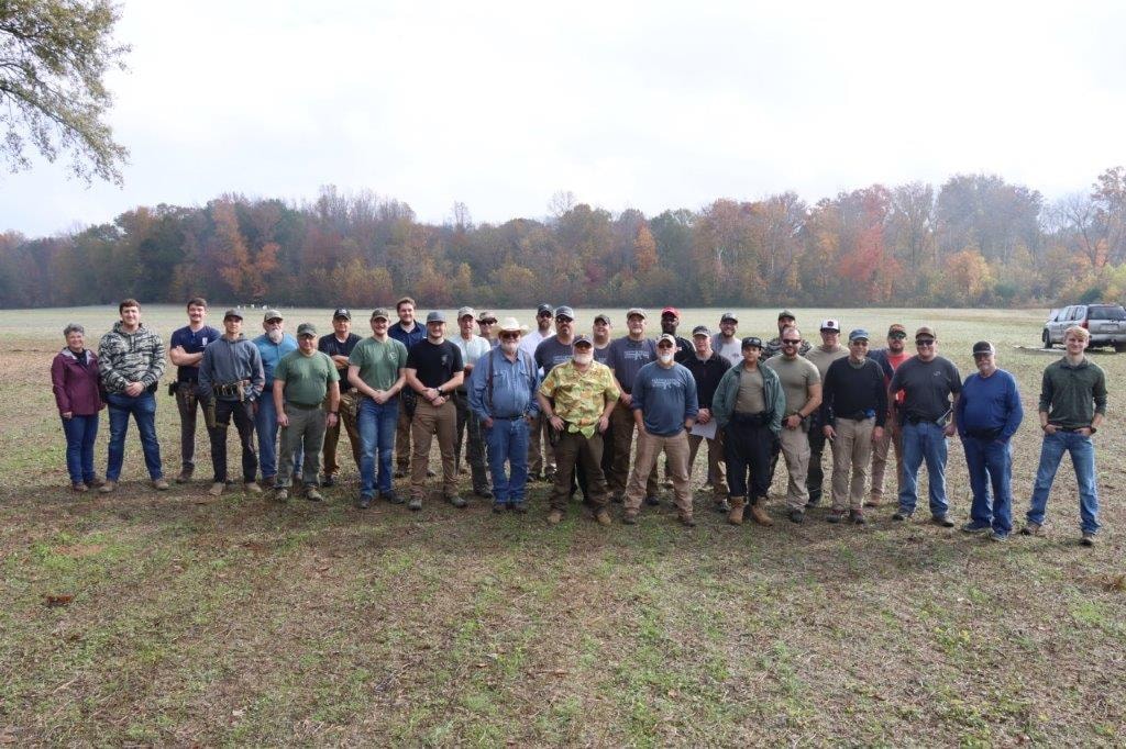 Multigun competitors and volunteers gathered outdoors