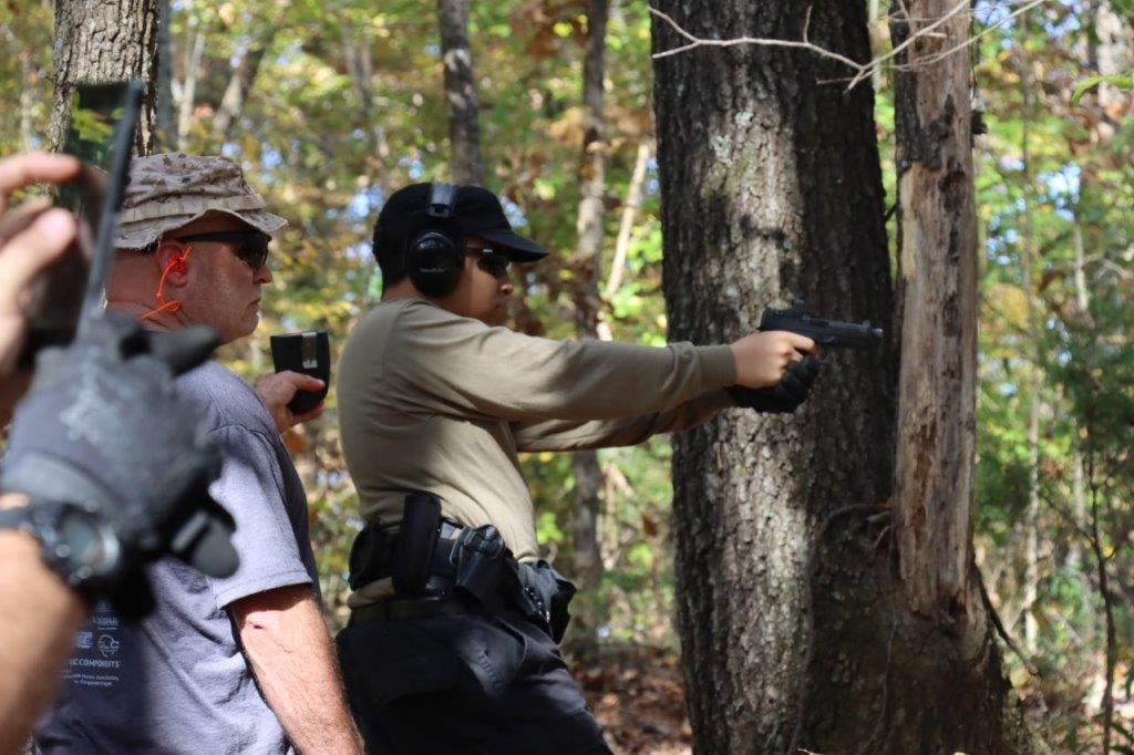 Competitors participating in a wooded outdoor shooting stage